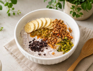 Maqui berry yogurt bowl topped with banana, passionfruit, granola, pistachios and cacao nibs.