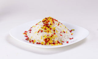 Decorating basmati rice with pistachios, barberries and saffron